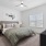 spacious bedroom with ceiling fan and light fixture